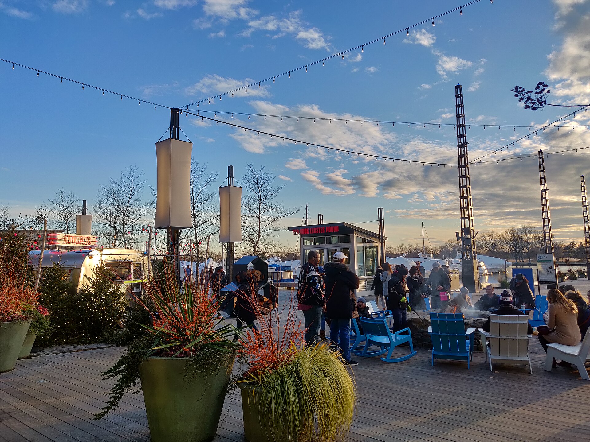 Wooden pier deck with a fire pit and chairs at The Wharf